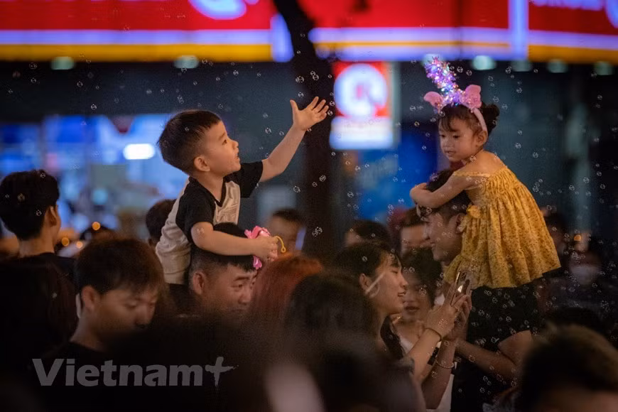 Los niños, traídos por sus familias aquí, experimentan la atmósfera del Festival del Medio Otoño en la calle de Hang Ma.