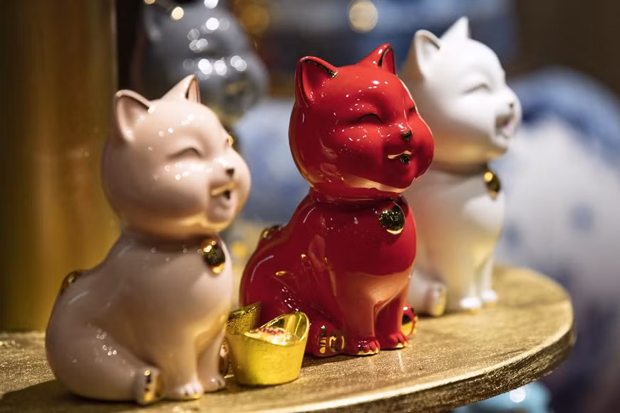 Estatua de gato de mil felicidades con decoración dorada.