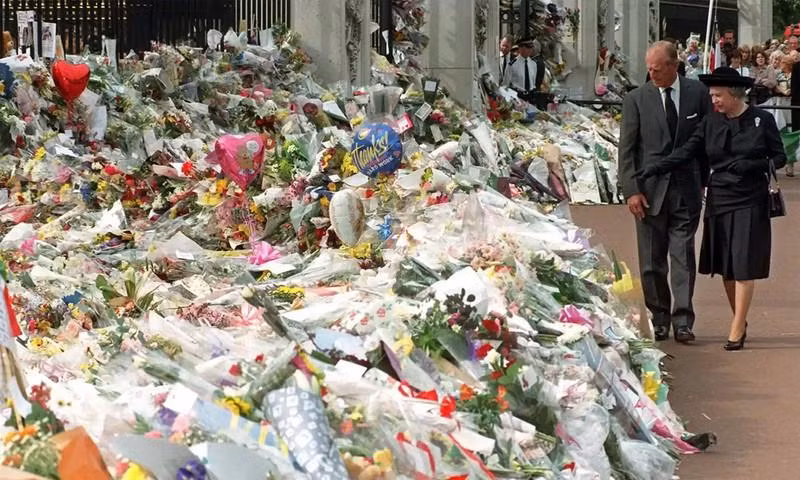 La reina y su cónyuge observan los miles de ramos de flores depositados por ciudadanos en el exterior del Palacio de Buckingham en memoria de Diana, princesa de Gales, en 1997. (Fotografía: PA)