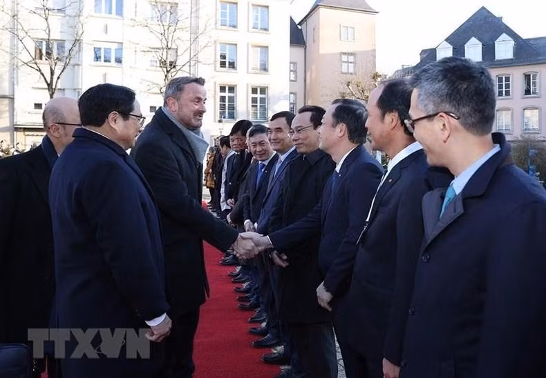 El premier vietnamita presenta a su homólogo del país europeo a los miembros de su delegación.