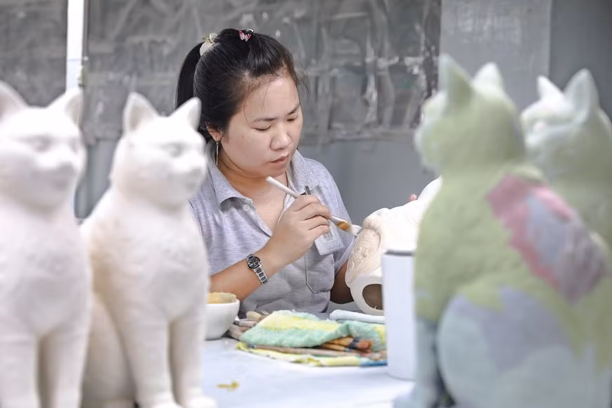 La etapa de coloreado y edición de los motivos de la estatua del gato antes de la entrada al horno.