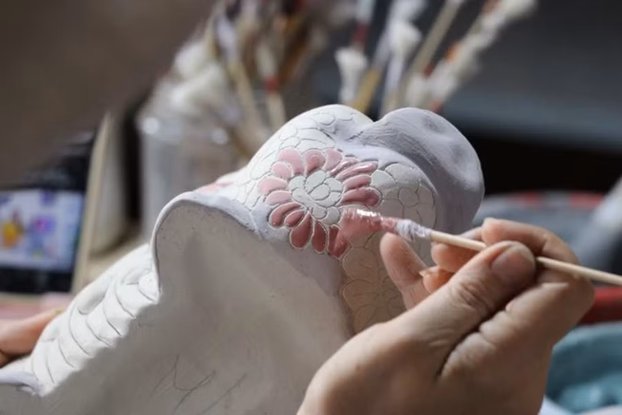 Artistas aplican esmalte y dibujan patrones en productos cerámicos de Bien Hoa en el horno de alfarería de Phong Son.