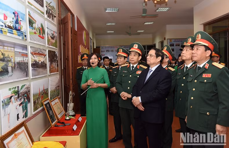 El premier vietnamita escucha la presentación sobre los armamentos del cuerpo militar.