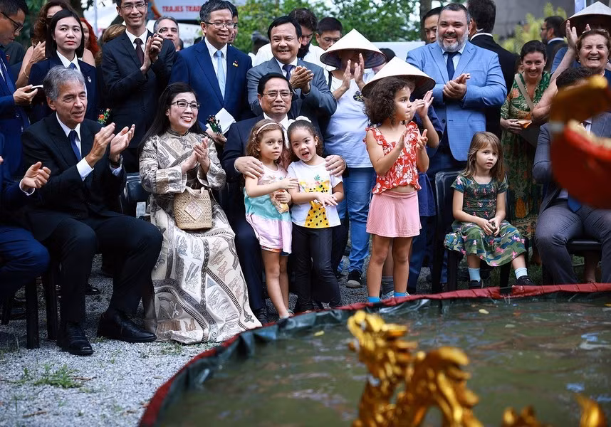El premier vietnamita, Pham Minh Chinh, su esposa y los delegados disfrutan de títeres de agua.