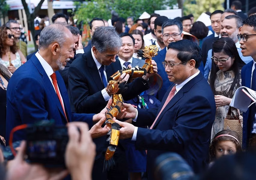 El premier vietnamita, Pham Minh Chinh, entrega marionetas de agua a los delegados.