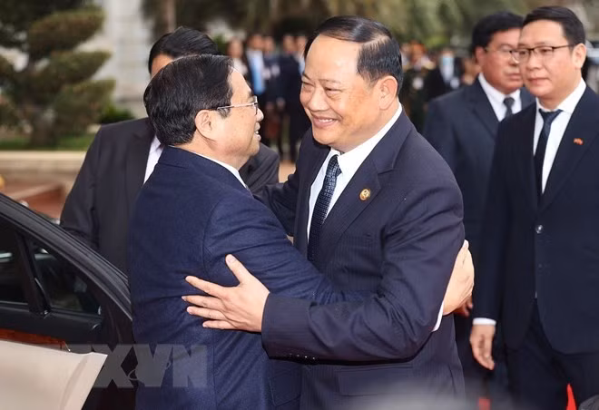 El premier laosiano, Sonexay Siphandone, da la bienvenida a su par vietnamita, Pham Minh Chinh.