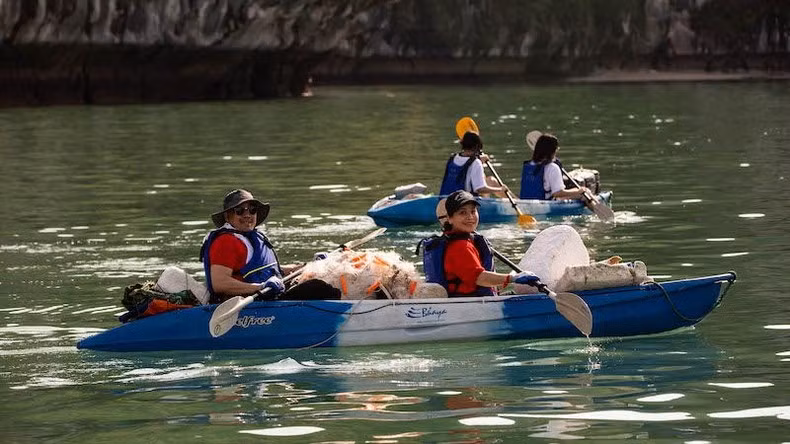 Los voluntarios reman en kayaks para recoger desechos que flotan en el mar. Los voluntarios reman en kayaks para recoger desechos que flotan en el mar.