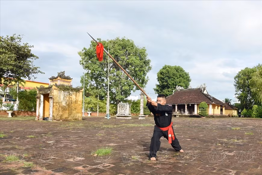 El maestro Ha Nhat Linh enseña a realizar una postura típica del arte marcial El maestro Ha Nhat Linh enseña a realizar una postura típica del arte marcial