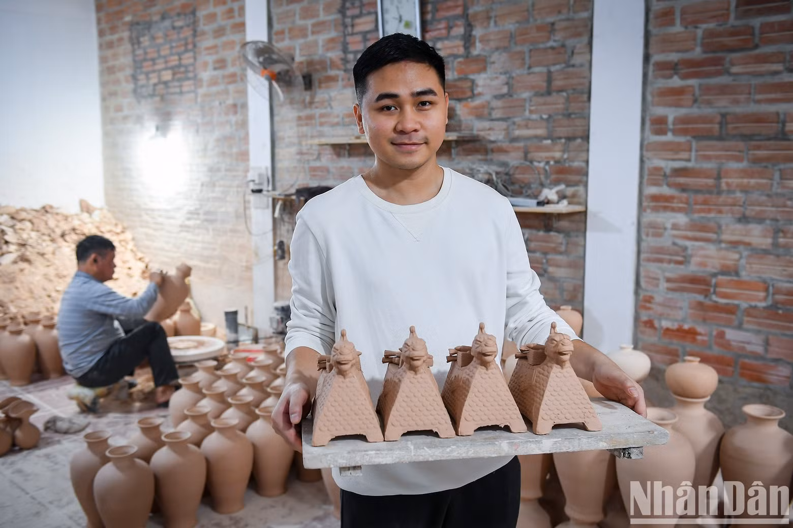 El joven artesano Anh Tu y sus obras.