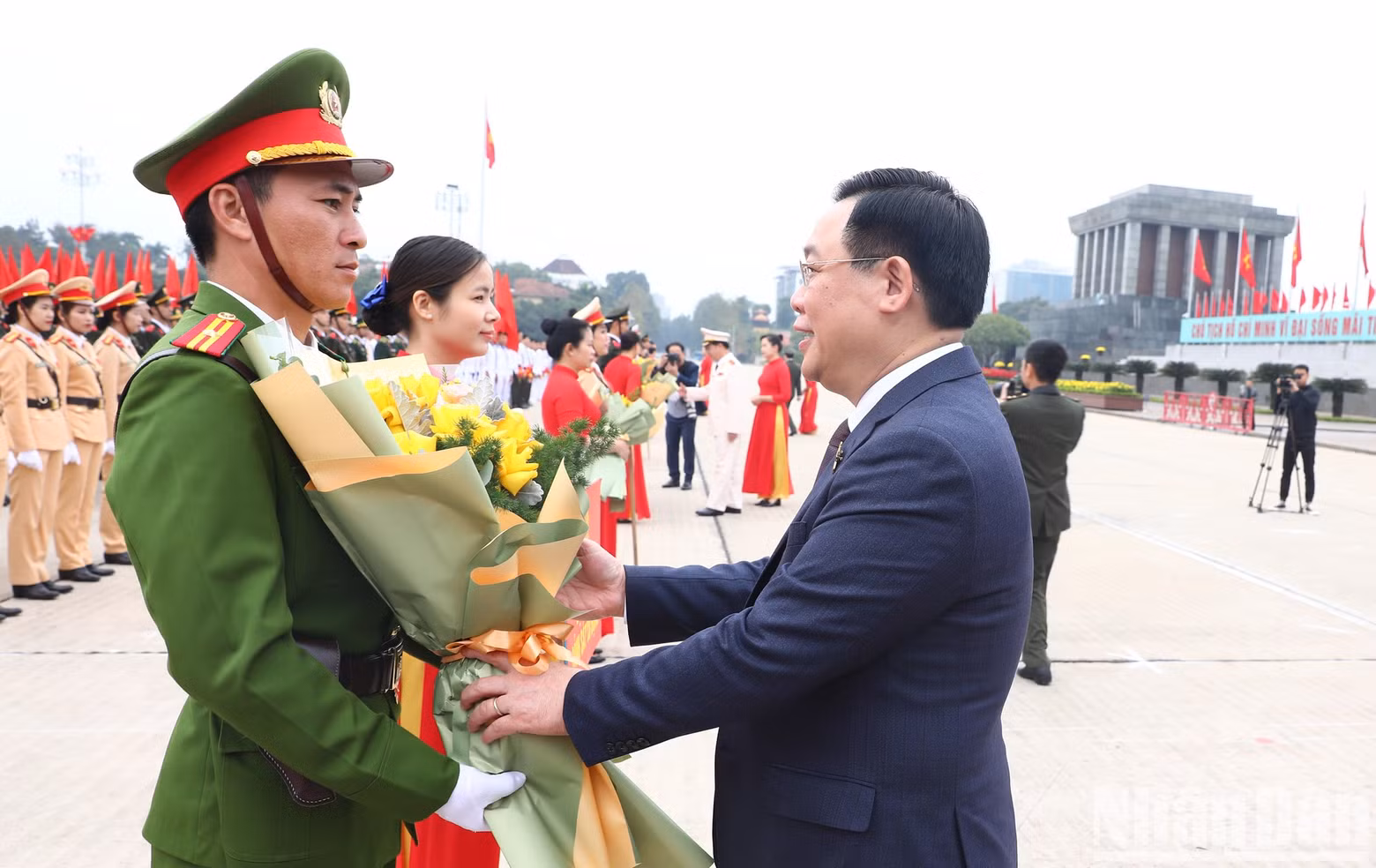 El titular del Parlamento vietnamita, Vuong Dinh Hue, entrega flores a los representantes de las delegaciones.