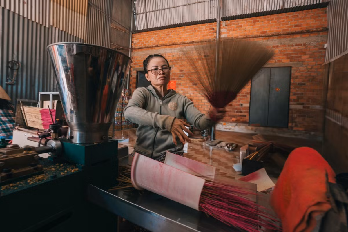 En un establecimiento de fabricación, el artesano selecciona y agita varitas de incienso para retirar las de calidad inferior. Las varillas de inciensos se hacen de bambú, se parten en trozos pequeños y se secan al sol durante muchos días para que sea más fácil pegarles el polvo.