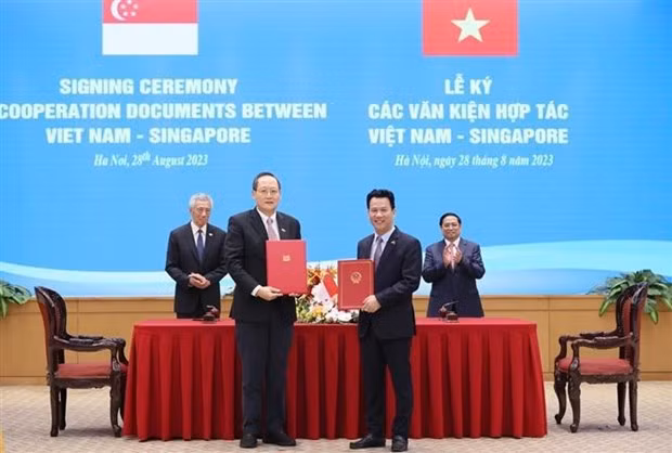 El primer ministro vietnamita, Pham Minh Chinh, y su homólogo singapurense, Lee Hsien Loong, presenciaron la firma de la Carta de Intención entre los Ministerios de Recursos Naturales y Medio Ambiente de Vietnam y de Industria y Comercio de Singapur sobre la implementación continua del Memorando de Entendimiento sobre la cooperación según el artículo 6 del Acuerdo de París (Fuente: VNA)