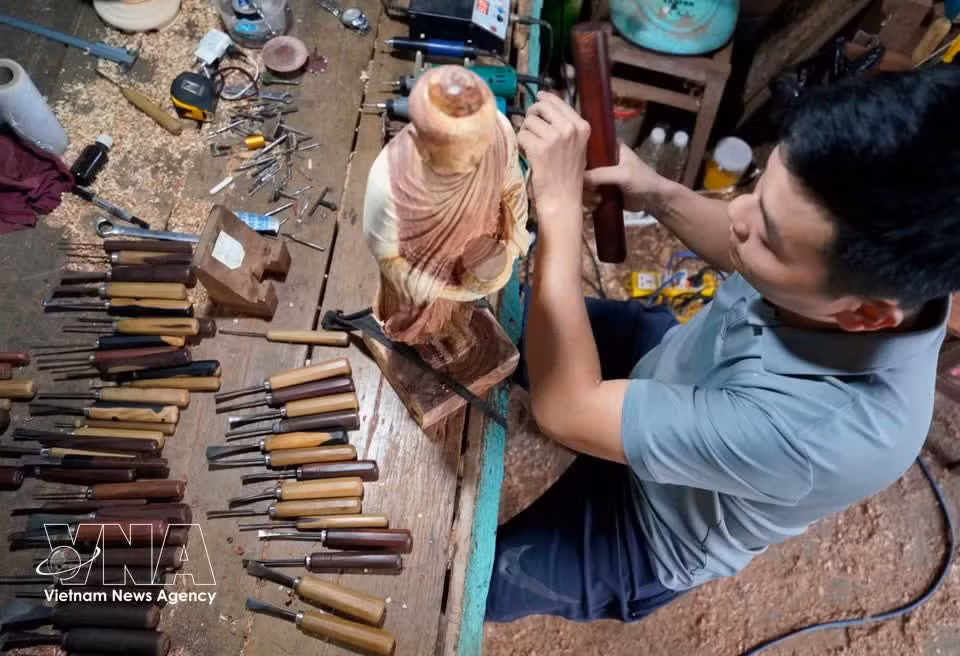Con sus hábiles manos, los artesanos infunden vida a cada fibra de madera mediante grabados laboriosos y minuciosos. (Foto: VNA)