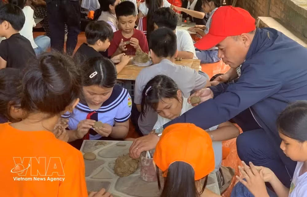 Los alumnos de la Escuela Primaria Phu My 1 experimentan la elaboración de cerámica en la aldea de alfarería de Phuoc Tich (ciudad de Hue). (Foto: VNA)