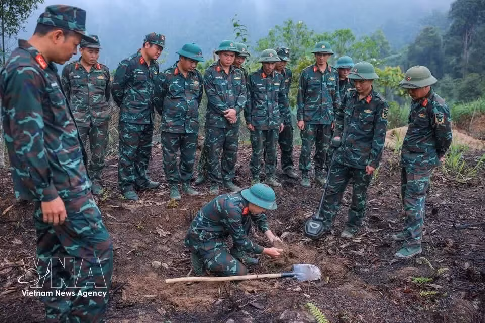 Los integrantes del equipo utilizan equipos de detección de minas para garantizar la seguridad del terreno antes de iniciar las labores de búsqueda. (Foto: VNA)