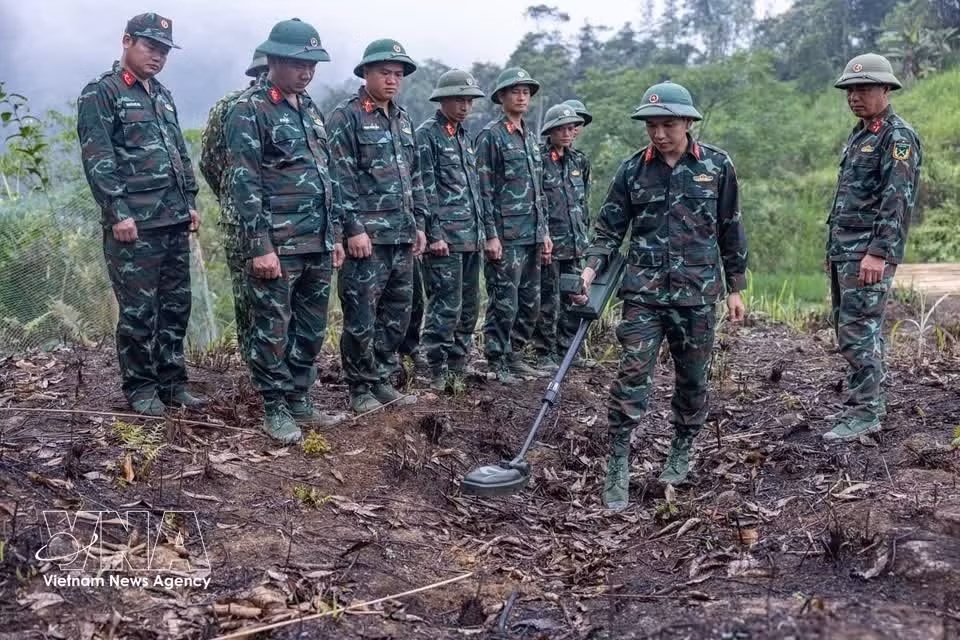 Los miembros del equipo continúan su preparación y uso especializado de detectores de minas para garantizar que el área esté segura antes de iniciar la búsqueda. (Foto: VNA)