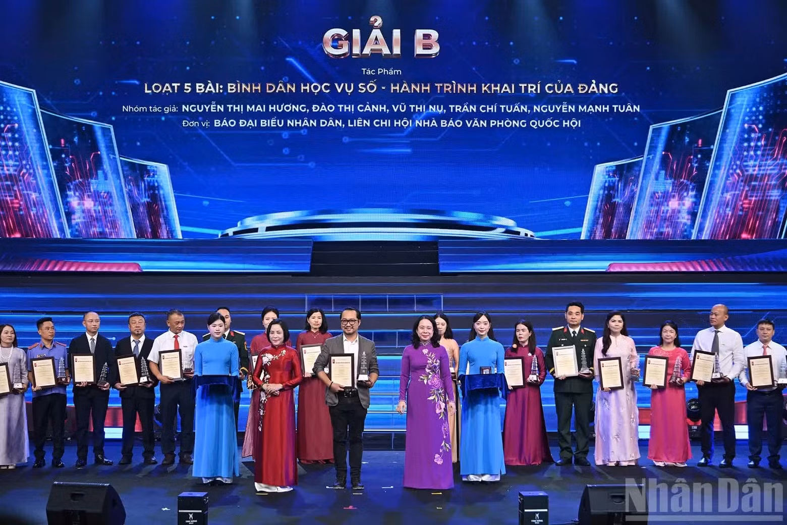 La vicepresidenta Vo Thi Anh Xuan y la vicepresidenta de la Asamblea Nacional, Nguyen Thi Thanh, entregan premios B a representantes de los grupos de autores galardonados de Nhan Dan.