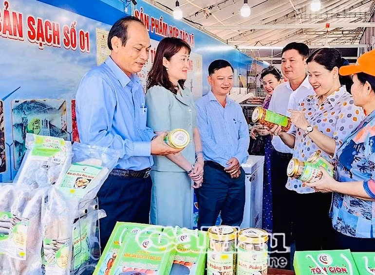 To Viet Thu, miembro permanente del Comité del Partido y secretario del barrio de Bac Lieu (segundo a la derecha), visita el pabellón de productos OCOP de la localidad.