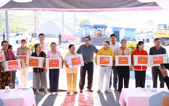 El primer ministro Pham Minh Chinh entrega obsequios a los habitantes de las zonas de reasentamiento de las comunas de Tuy An Tay y Tuy An Nam, provincia de Dak Lak. (Foto: VNA)