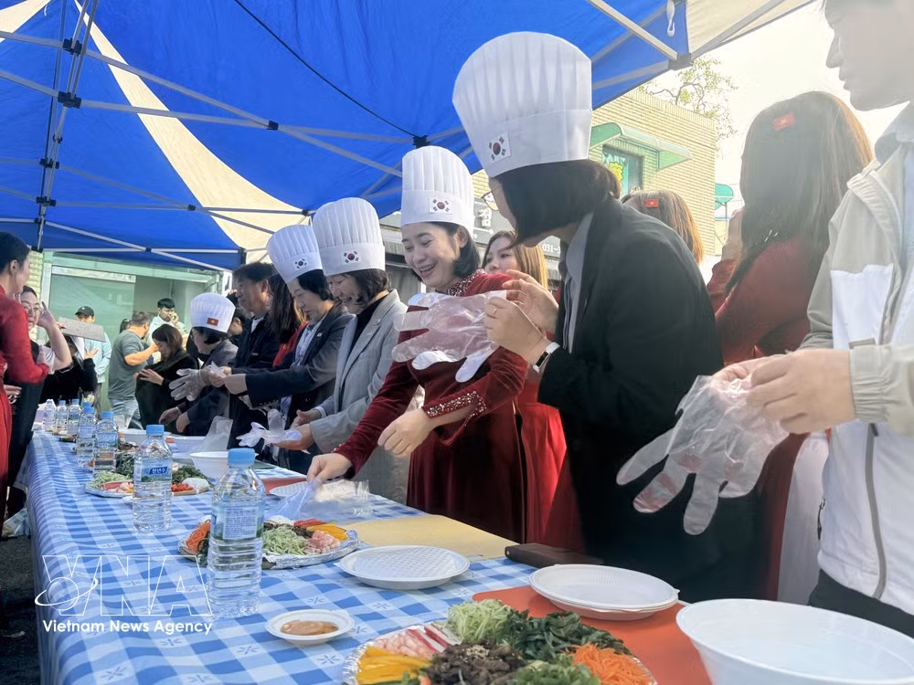 Los delegados e invitados participan en una degustación de rollitos tradicionales de primavera de Vietnam. (Foto: VNA)
