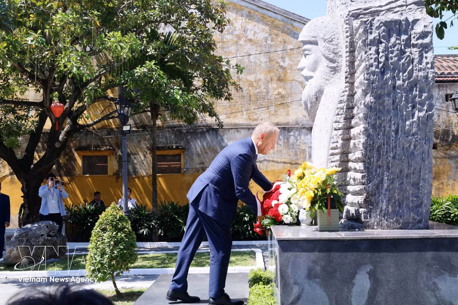 El primer ministro Donald Tusk deposita una corona de flores en el monumento al arquitecto polaco Kazimierz Kwiatkowski en el casco antiguo de Hoi An. (Foto: VNA)