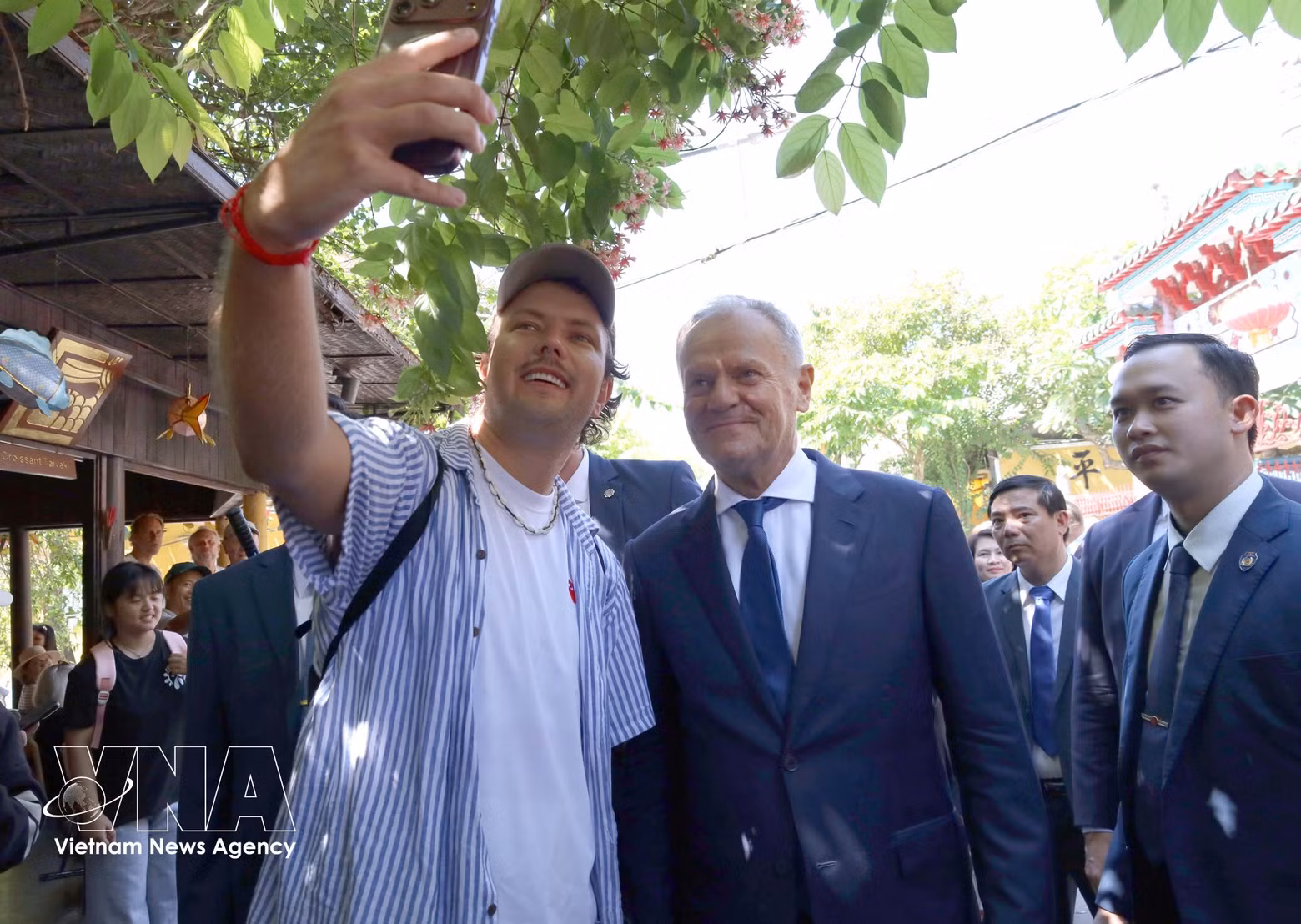 Turistas posan para fotos con el primer ministro polaco Donald Tusk en la Ciudad Antigua de Hoi An. (Foto: VNA)