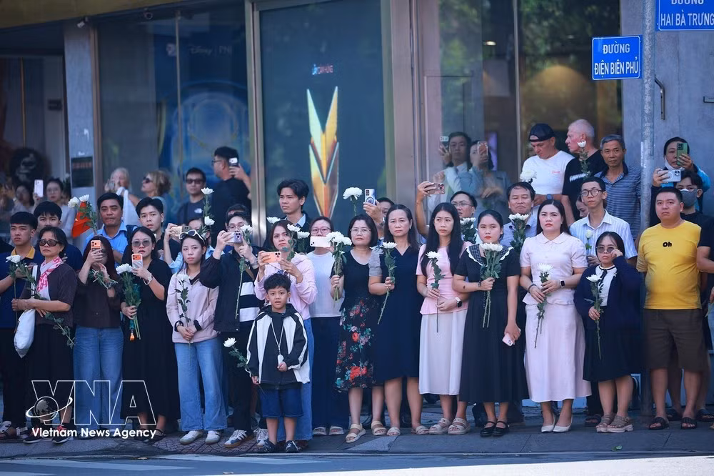 Un gran número de residentes de Ciudad Ho Chi Minh, portando flores blancas, despiden los restos de mártires mientras son trasladados al Cementerio de Mártires de Ciudad Ho Chi Minh. (Foto: VNA)