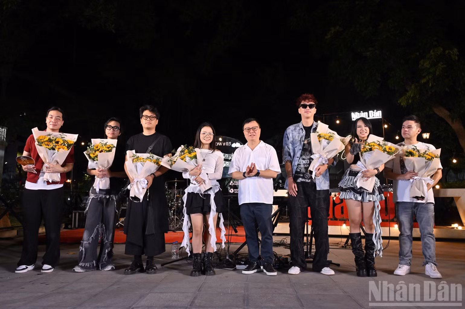 El presidente editor de Nhan Dan, Le Quoc Minh, entrega flores a los artistas y grupos participantes.