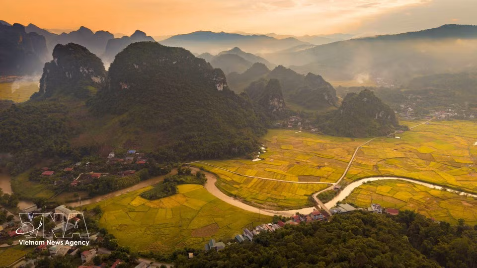El valle queda sumido en la luz del atardecer, con montañas rocosas, arrozales y un río serpenteante que se integran en el paisaje montañoso. (Foto: VNA)
