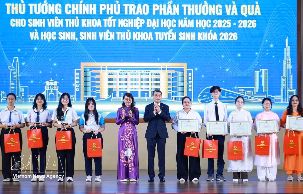 El primer ministro Le Minh Hung entrega obsequios a los estudiantes con mejores expedientes académicos de la promoción 2025-2026 y a los alumnos con las mejores calificaciones de ingreso en 2026. (Foto: VNA)