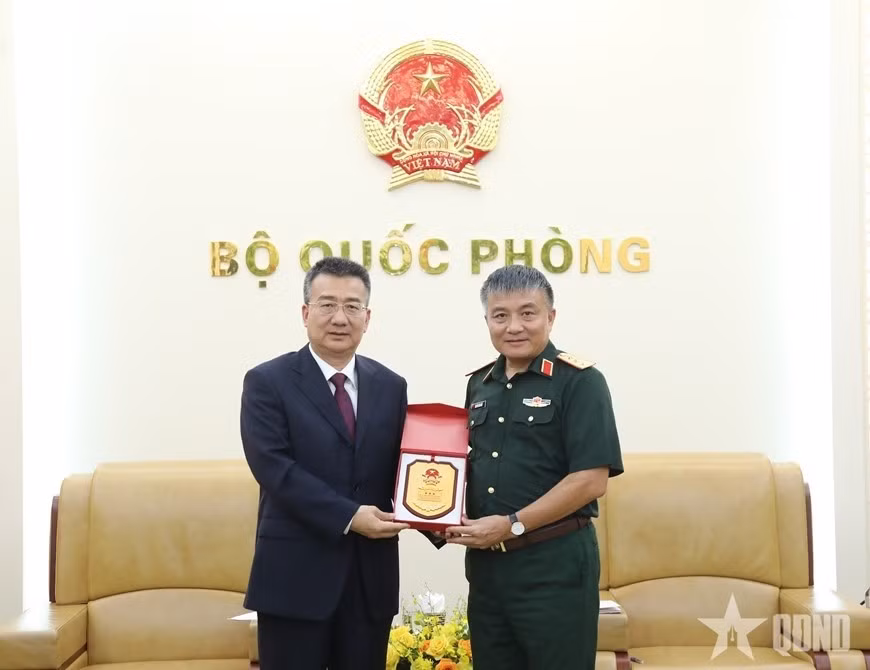 El viceministro de Defensa de Vietnam, Nguyen Van Hien (derecha), intercambia un obsequio con Lyu Wuqin, asistente del ministro de Seguridad Pública de China. (Foto: qndn.vn)