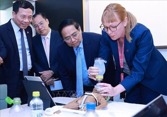 El primer ministro Pham Minh Chinh observa una simulación de atención de emergencia neonatal realizada con las tecnologías desarrolladas por el Instituto Karolinska. (Foto: VNA)