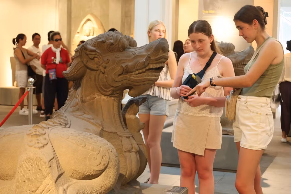 Visitantes extranjeros exploran la estatua del monstruo acuático Makara en la cultura Cham. (Foto: VNA)
