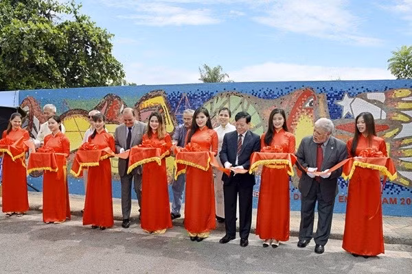 El embajador de Chile en Vietnam, Claudio De Negri, y los delegados cortan la cinta inaugural de un tramo del Mural Mosaico Cerámico en Hanói, diseñado por el artista chileno Alejandro Mono González, el 18 de septiembre de 2017, en ocasión del 207º aniversario de la Independencia Nacional de Chile. (Foto: VUFO)