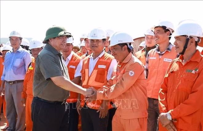 El primer ministro Pham Minh Chinh con ingenieros y trabajadores que construyen el proyecto de la línea de transmisión de 500 kV Lao Cai - Vinh Yen. (Foto: VNA)