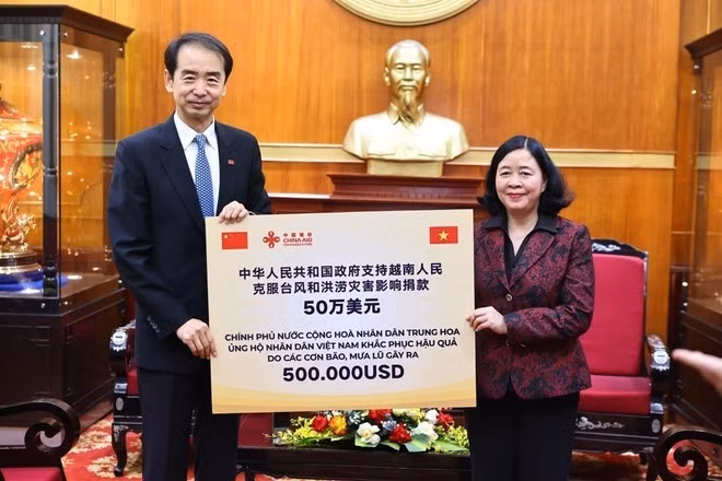 La presidenta del Comité Central del Frente de la Patria de Vietnam (FPV), Bui Thi Minh Hoai, recibe una donación de asistencia financiera de 500.000 dólares del Gobierno chino para la población de las provincias recientemente afectadas por desastres naturales (Foto: VNA)