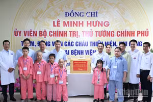 El primer ministro Le Minh Hung entrega los regalos enviados por el secretario general del Partido Comunista y presidente del Estado, To Lam, a los pacientes pediátricos que reciben tratamiento en el Hospital K, centro de Tan Trieu, barrio de Thanh Liet.