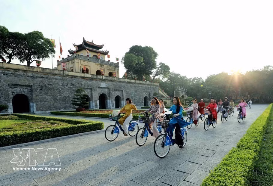 Mujeres de Hanói, vestidas con el traje tradicional Ao Dai, recorren en bicicleta los sitios patrimoniales de la ciudad durante el primer evento "Ao Dai conecta el turismo y el patrimonio de Hanói" en 2023.