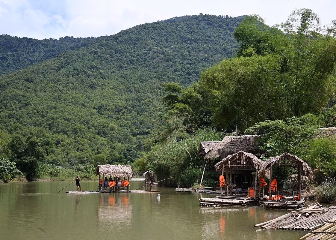 Los visitantes admiran el pintoresco paisaje del arroyo Cham desde una balsa de bambú.