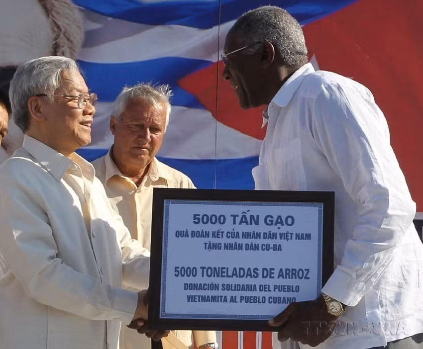 El secretario general del Partico Comunista de Vietnam, Nguyen Phu Trong, entrega simbólicamente al secretario general de la Central de Trabajadores de Cuba, Salvador Valdés Mesa, una donación de cinco mil toneladas de arroz del pueblo vietnamita a su par cubano (La Habana, 11 de abril de 2012). (Foto: VNA)