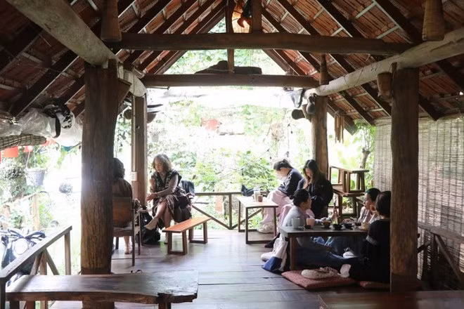 Los turistas disfrutan de café en el entorno de una casa sobre pilotes en Dak Lak. (Foto: VNA)