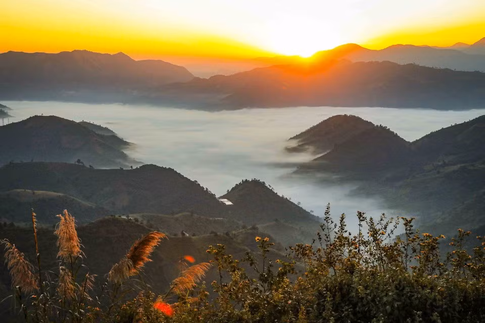 El sol sale tras los picos de las montañas en el paso de Keo Lom.