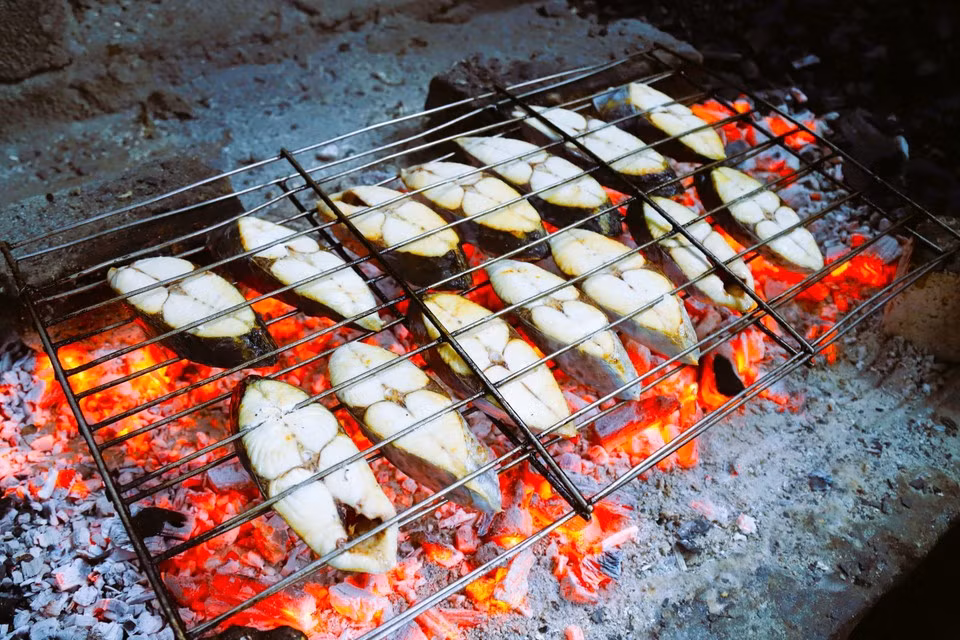 Tras las etapas de preparación, limpieza y secado natural, el pescado “Thu” (caballa) se dispone de manera uniforme y se asa sobre capas de carbón al rojo vivo.