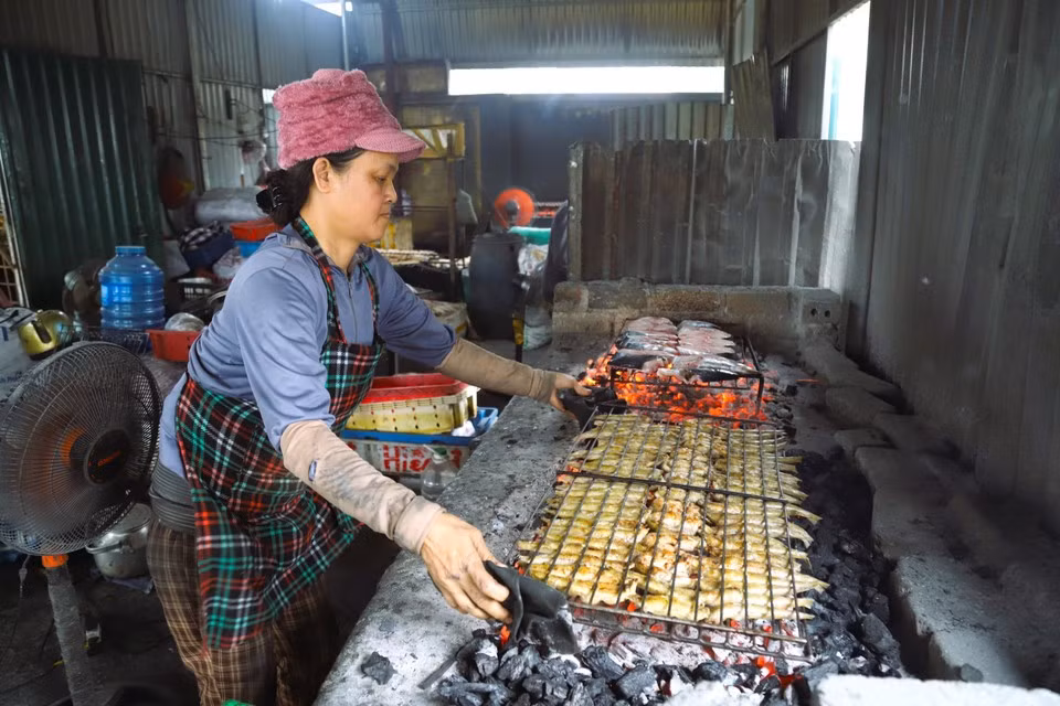 Mujeres de la aldea costera de Yen Thinh asan pescado con carbón vegetal en un horno situado junto a la desembocadura marina de Lach Van.