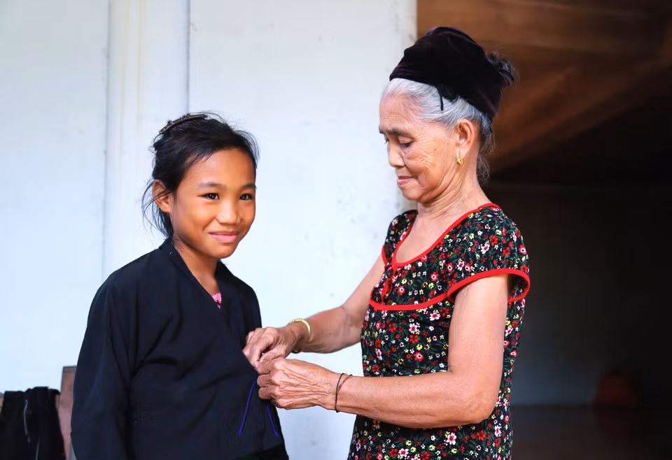 Los niños O'du aprenden de los adultos cómo vestir el traje tradicional antes de participar en la ceremonia del primer trueno, el ritual de atado de hilos en la muñeca y la ceremonia de nombramiento.