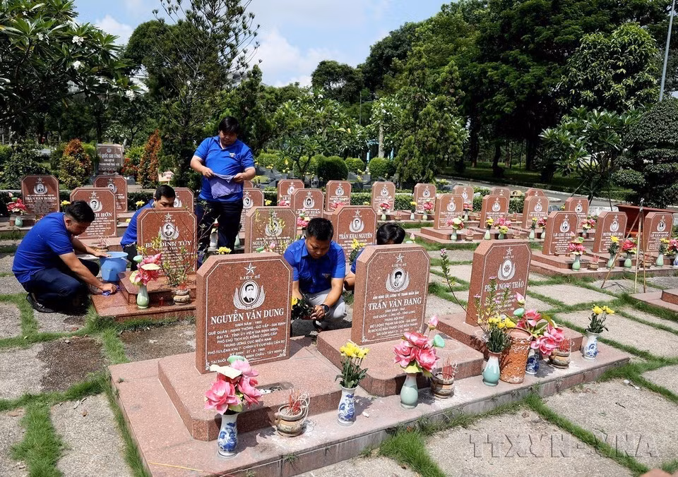 Miembros de la filial de la Unión de Jóvenes Comunistas Ho Chi Minh del barrio de Long Binh, ciudad de Thu Duc, cuidan las tumbas de comabtientes en el Cementerio de los Mártires de Ciudad Ho Chi Minh.