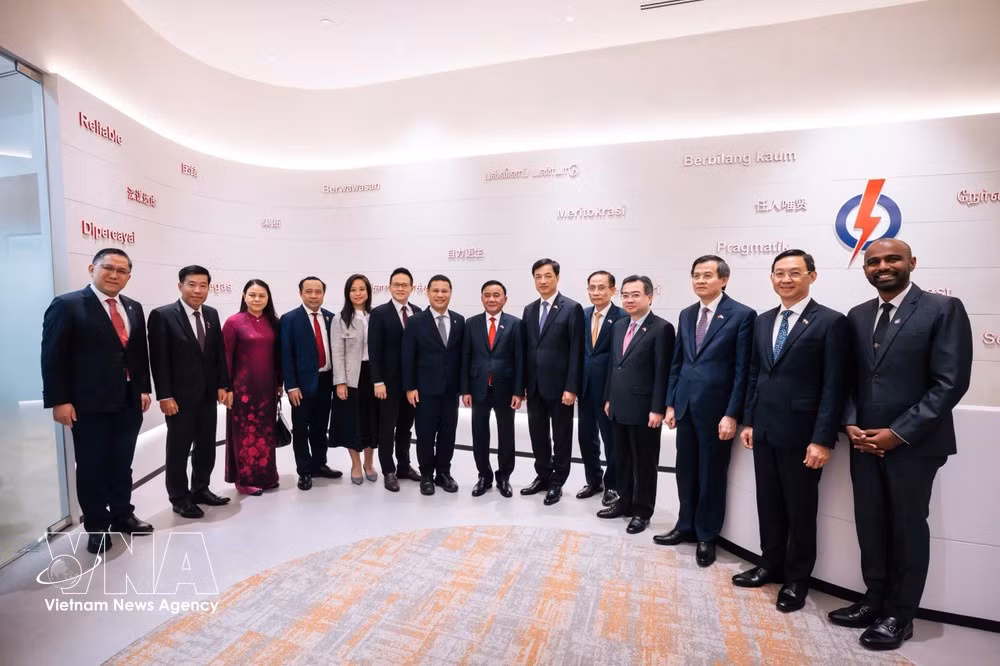 El miembro del Buró Político e integrante permanente del Secretariado del Comité Central del PCV, Tran Cam Tu, el presidente del Partido de Acción Popular y ministro de Educación de Singapur, Desmond Lee, y delegados. (Foto: VNA)