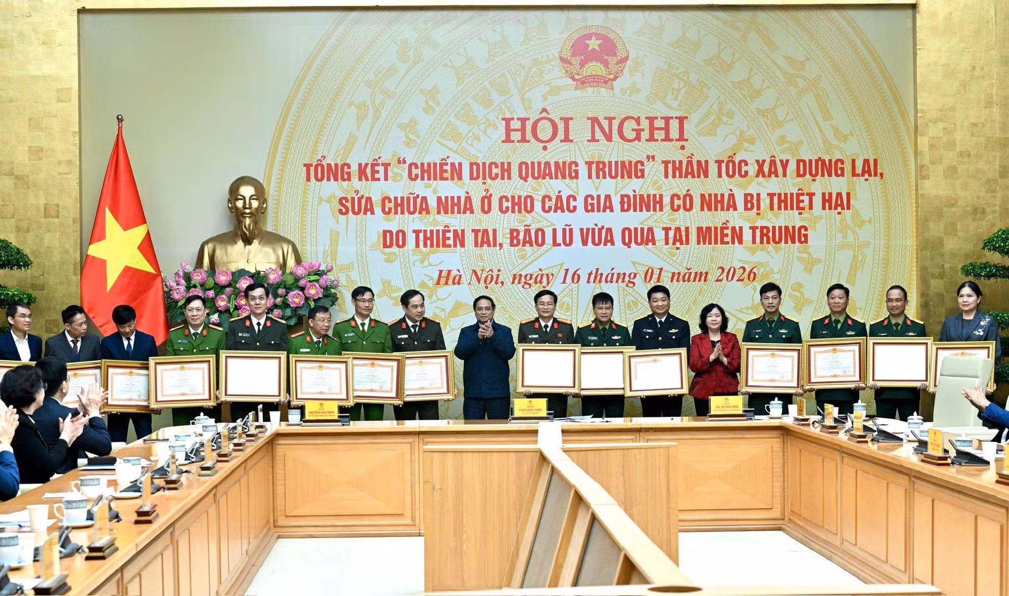 El primer ministro Pham Minh Chinh y la presidenta del Presidium del Comité Central del Frente de la Patria de Vietnam, Bui Thi Minh Hoai, entregan certificados de mérito a los colectivos con logros destacados en la “Campaña Quang Trung”.