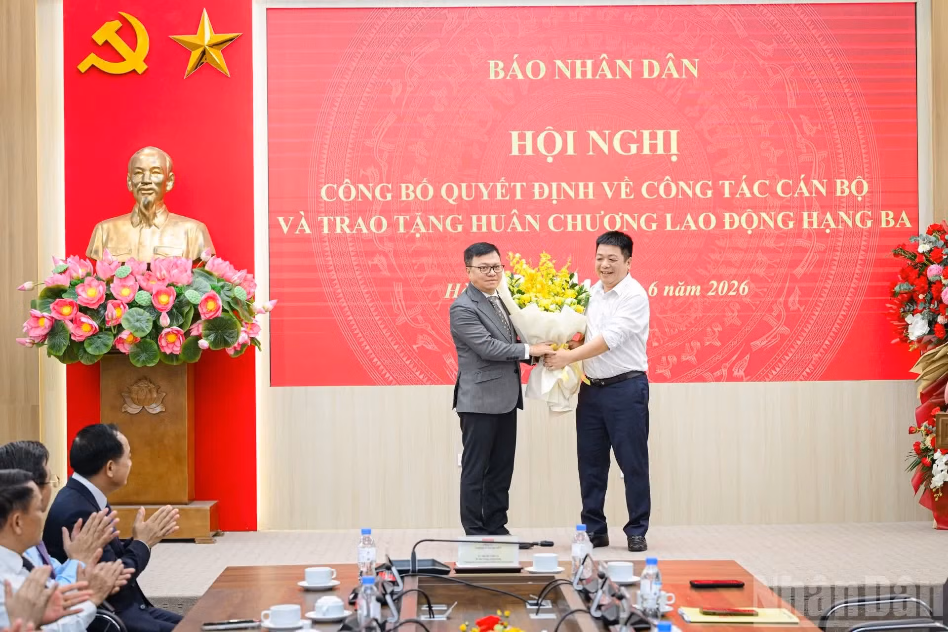El vicepresidente-editor del periódico Nhan Dan, Que Dinh Nguyen, felicita a Le Quoc Minh en representación del diario.