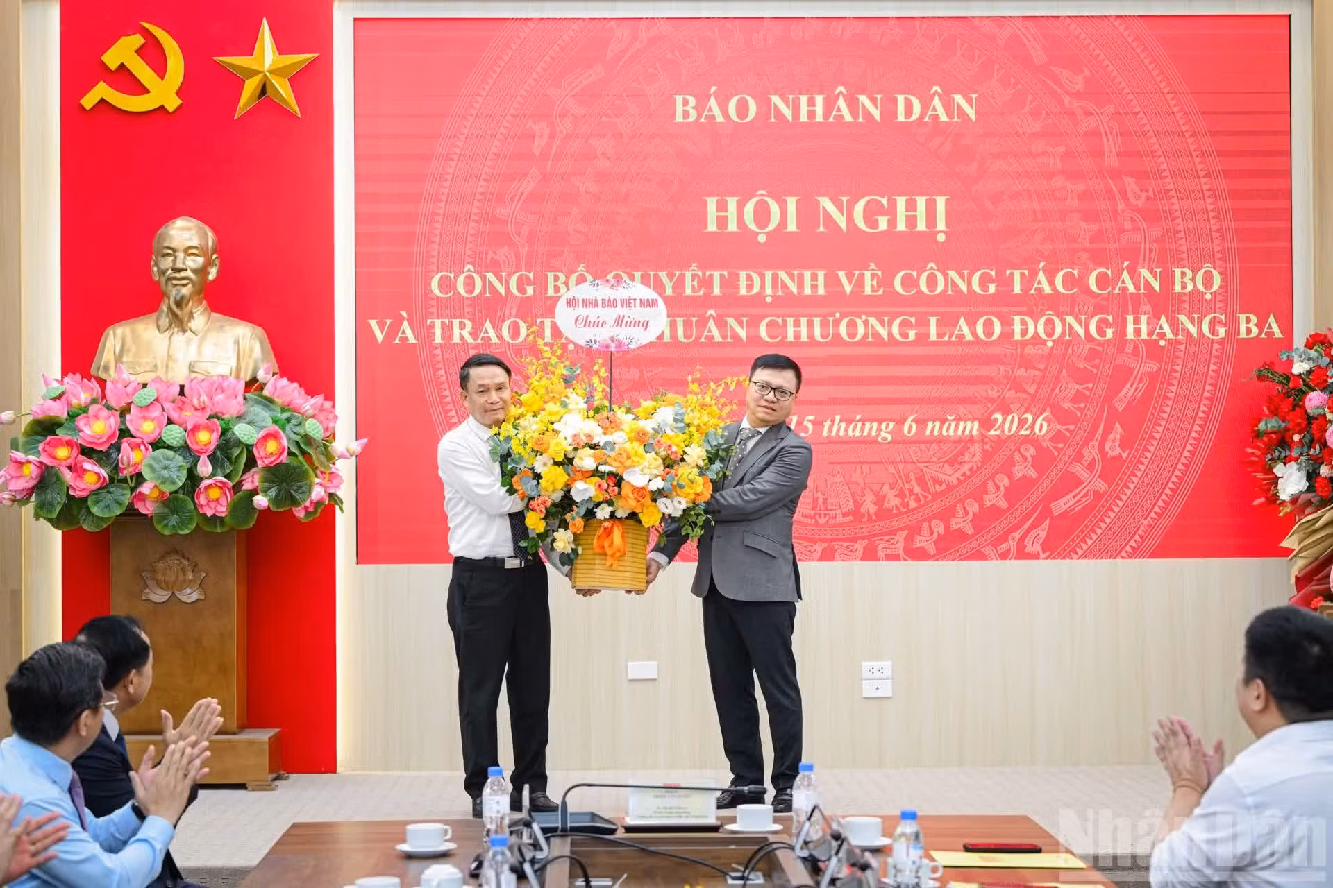 El vicepresidente permanente de la Asociación de Periodistas de Vietnam, Nguyen Duc Loi, entrega flores de felicitación a Le Quoc Minh.